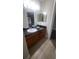 Bathroom vanity with granite countertop, wood cabinets, and a large mirror at 445 Fountainhead Cir # 262, Kissimmee, FL 34741