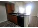 Modern kitchen with sleek black appliances, wood cabinets and a convenient breakfast bar at 445 Fountainhead Cir # 262, Kissimmee, FL 34741
