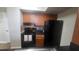 Well-equipped kitchen featuring black appliances, wood cabinets, and colorful backsplash at 445 Fountainhead Cir # 262, Kissimmee, FL 34741