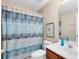Well-lit bathroom featuring a vanity, toilet, and shower with a patterned curtain at 449 Cruz Bay Cir, Winter Springs, FL 32708