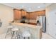 Kitchen featuring wood cabinets, stainless steel appliances, breakfast bar, and modern lighting fixtures at 449 Cruz Bay Cir, Winter Springs, FL 32708