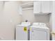 Laundry room with a white washer and dryer, and overhead storage cabinets at 449 Cruz Bay Cir, Winter Springs, FL 32708