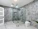 Bathroom features a glass-enclosed shower with tile surround, a mosaic floor, and a modern toilet at 516 Petes Ln, Davenport, FL 33837