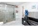 Modern bathroom featuring a sleek black bathtub, glass-enclosed shower, and elegant gray tile at 516 Petes Ln, Davenport, FL 33837