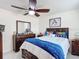 Bright bedroom with ceiling fan, large bed, and matching dresser and nightstands at 516 Petes Ln, Davenport, FL 33837