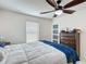Inviting bedroom featuring a ceiling fan, comfortable bed, and a dresser for extra storage at 516 Petes Ln, Davenport, FL 33837