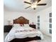 Cozy bedroom featuring a large bed with decorative pillows and a ceiling fan at 516 Petes Ln, Davenport, FL 33837