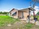 Back exterior of home with covered porch, seating area, and well-manicured lawn at 516 Petes Ln, Davenport, FL 33837
