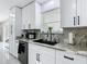 Updated kitchen with white cabinets, marble backsplash and countertops, and modern black hardware and fixtures at 516 Petes Ln, Davenport, FL 33837