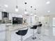 Bright, modern kitchen with island, bar seating, and sleek appliances with marble backsplash at 516 Petes Ln, Davenport, FL 33837