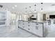 Spacious kitchen with marbled countertop island, modern lighting and white cabinetry at 516 Petes Ln, Davenport, FL 33837