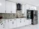 Bright kitchen featuring white cabinetry, stainless appliances, marble countertops and backsplash at 516 Petes Ln, Davenport, FL 33837