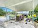 Outdoor patio features an entertaining area with a table, refrigerator and a grill at 516 Petes Ln, Davenport, FL 33837