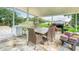 Outdoor patio features an entertaining area with a table, refrigerator and a grill at 516 Petes Ln, Davenport, FL 33837