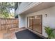 View of the backyard with a wood fence, exterior door and tropical foliage at 7475 Canford Ct # 21, Winter Park, FL 32792