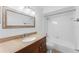 Bright bathroom featuring a granite countertop vanity and shower with white tile surround at 7475 Canford Ct # 21, Winter Park, FL 32792