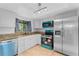 Bright kitchen featuring updated appliances, granite counters, and tile flooring at 7475 Canford Ct # 21, Winter Park, FL 32792