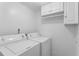 Laundry area featuring a washer, dryer, and white cabinets at 7475 Canford Ct # 21, Winter Park, FL 32792