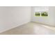 Cozy bedroom with a large window, neutral wall paint, and tile flooring at 797 Lemon Ave, Fruitland Park, FL 34731