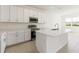 Well-lit kitchen with white cabinets, stainless appliances, and quartz countertops at 797 Lemon Ave, Fruitland Park, FL 34731