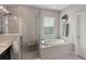 Relaxing bathroom with a soaking tub, tiled shower, and bright natural light from the window at 859 Easley Ave, Winter Garden, FL 34787