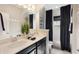 Modern bathroom with double sinks, sleek fixtures, black hardware and a shower-tub combo at 859 Easley Ave, Winter Garden, FL 34787