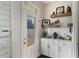 Well organized mud room with white cabinets, wood shelving and bright natural light from the exterior door at 859 Easley Ave, Winter Garden, FL 34787