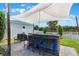 Outdoor kitchen area featuring a grill, outdoor seating, and a protective sunshade at 859 Easley Ave, Winter Garden, FL 34787