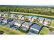 An aerial view showcases a neighborhood with beautiful homes, backyard pools, and a serene lake surrounded by lush greenery at 8622 La Isla Dr, Kissimmee, FL 34747