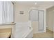 Bright bathroom featuring soaking tub and glass-enclosed shower at 8622 La Isla Dr, Kissimmee, FL 34747