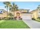 Charming two-story home features a well-manicured lawn and a two-car garage at 8622 La Isla Dr, Kissimmee, FL 34747