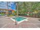 Inviting community hot tub with brick-paved surround, landscaping, and beautiful sky at 8622 La Isla Dr, Kissimmee, FL 34747