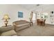 Living room with plush carpeting adjacent to an open dining area for seamless entertaining at 8622 La Isla Dr, Kissimmee, FL 34747