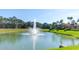 Scenic community pond with a central fountain and lush green surroundings under a clear sky at 8622 La Isla Dr, Kissimmee, FL 34747