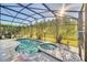 A screened-in pool with an attached spa offers a private retreat for relaxation and recreation in a backyard oasis at 8622 La Isla Dr, Kissimmee, FL 34747