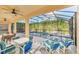 A luxurious outdoor living space features an enclosed pool, spa, and a shaded patio with comfortable seating and dining at 8622 La Isla Dr, Kissimmee, FL 34747