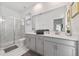 Luxurious bathroom with a double sink vanity, marble floors, a glass-enclosed shower, and modern fixtures at 9227 Sommerset Hills Dr, Davenport, FL 33896
