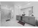 Spacious bathroom with a double sink vanity, large mirror, glass-enclosed shower, and modern fixtures at 9227 Sommerset Hills Dr, Davenport, FL 33896