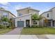 Charming two-story home with a stone accent wall, a green garage door, and a well-manicured lawn at 9227 Sommerset Hills Dr, Davenport, FL 33896