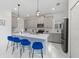 Bright kitchen featuring a large island with counter seating, gray cabinets, and modern pendant lighting at 9227 Sommerset Hills Dr, Davenport, FL 33896