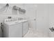 Functional laundry room featuring a washer, dryer, wire shelving, and marble-look tile flooring at 9227 Sommerset Hills Dr, Davenport, FL 33896