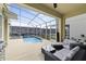Relaxing screened-in patio with a pool, lounge area, and outdoor cooking space at 9227 Sommerset Hills Dr, Davenport, FL 33896