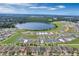 Aerial view of a residential neighborhood surrounding a scenic lake, showcasing a mix of completed and in-progress homes at 928 Pearlwood Loop, Eagle Lake, FL 33839