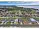Expansive aerial view of a lakeside residential community with new homes and construction sites under a blue, cloudy sky at 928 Pearlwood Loop, Eagle Lake, FL 33839