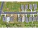 Aerial view of a neighborhood with rooftops and a long black street on a bright sunny day at 928 Pearlwood Loop, Eagle Lake, FL 33839