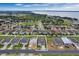 Expansive aerial view of a lakeside residential community with new homes and construction sites under a blue, cloudy sky at 928 Pearlwood Loop, Eagle Lake, FL 33839