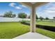 View of the spacious backyard with a white fence, green grass, and a concrete patio area at 928 Pearlwood Loop, Eagle Lake, FL 33839