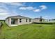 Beautiful backyard with lush green grass, an extended patio, and modern home exterior under a bright blue sky at 928 Pearlwood Loop, Eagle Lake, FL 33839