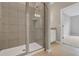 Modern bathroom showcases a glass shower with gray tiles, a neutral-toned vanity and tile flooring at 928 Pearlwood Loop, Eagle Lake, FL 33839