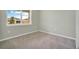 Bright bedroom featuring neutral carpet, a window with a backyard view, and ample natural light at 928 Pearlwood Loop, Eagle Lake, FL 33839